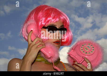 Femme avec une perruque rose téléphone rose Banque D'Images