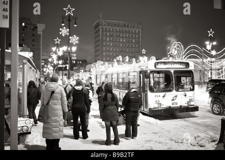Les navetteurs qui attendent un arrêt d'autobus pour une journée hivernale froide, le centre-ville de Winnipeg, au Manitoba, au Canada. Banque D'Images