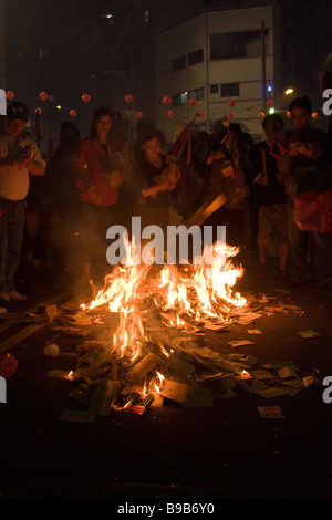 Les gens brûlent de l'argent fantôme sacrificiel aka joss sur la rue au cours de l'assemblée annuelle et de pèlerinages Mazu Festival, District de Dajia, Taichung, Taiwan Banque D'Images