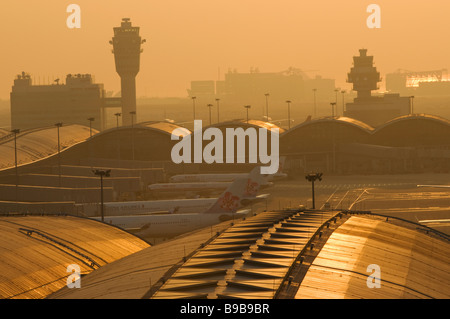 Le Smog enveloppe Hong Kong Chek Lap Kok au coucher du soleil. Banque D'Images