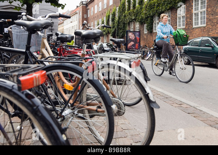 Copenhague, Danemark. Woman riding bicycle in city center Banque D'Images