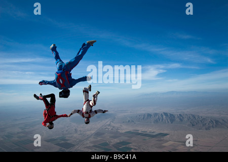 Trois parachutistes chute libre la tête la première avec des montagnes en arrière-plan Banque D'Images