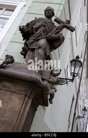 Statue de Saint Pierre avec croix sur chambre angle dans Mala Strana, Prague, République tchèque. Banque D'Images