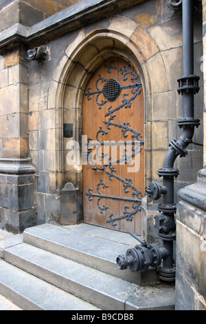 Vieille porte gothique de la cathédrale Saint-Guy avec tuyau métallique sur le premier plan. Banque D'Images