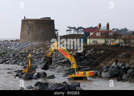 Rock amour étant placé sur le rivage pour protéger une tour Martello et maisons de l'érosion côtière, Bawdsey, Suffolk, UK. Banque D'Images