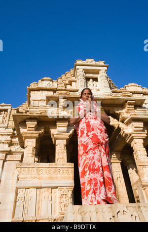 Femme debout dans une position de prière devant un temple, Temple de Kumbha Shyam, Chittorgarh, Rajasthan, Inde Banque D'Images