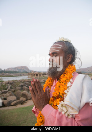 Sadhu debout dans une position de prière, Hampi, Karnataka, Inde Banque D'Images