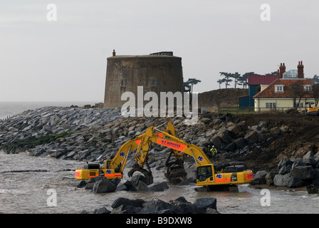 Rock amour étant placé sur le rivage pour protéger une tour Martello et maisons de l'érosion côtière, Bawdsey, Suffolk, UK. Banque D'Images