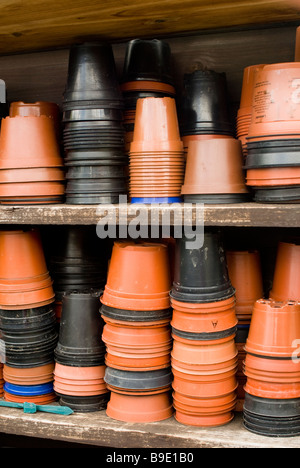 Des piles de pots en plastique stockés sur des étagères prêt pour l'utilisation dans le jardin Banque D'Images