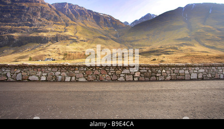 Contexte de la route goudronnée,avec mur de pierre panorama de montagnes au loin. Banque D'Images