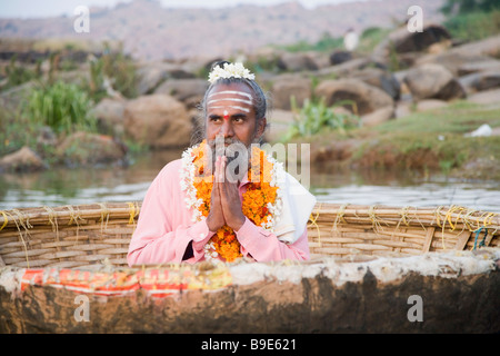 Une adoration en Sadhu, coracle Tungabhadra River, Hampi, Karnataka, Inde Banque D'Images