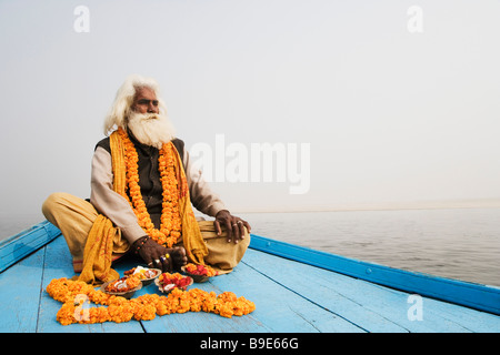 Sadhu assis dans un bateau et priant, Gange, Varanasi, Uttar Pradesh, Inde Banque D'Images