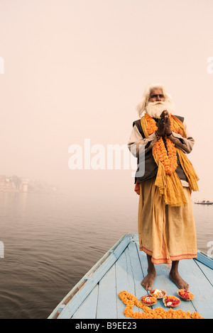 Sadhu debout sur un bateau et en priant, Gange, Varanasi, Uttar Pradesh, Inde Banque D'Images