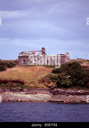 Maison d'habitation en ruine se trouve perdu sur le bord d'une mer d'irlande inlet Banque D'Images