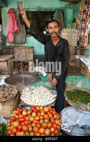 Vendeur de légumes avec une paire d'écailles sur son stand, Diphu, Assam Banque D'Images