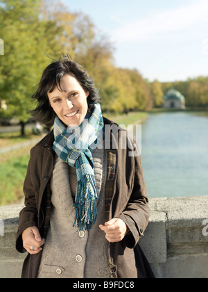 Portrait of young woman standing on bridge and smiling Banque D'Images