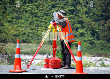 Surveyor travailler sur route avec réglage automatique du niveau, Paparoa National Park, West Coast, South Island, New Zealand Banque D'Images