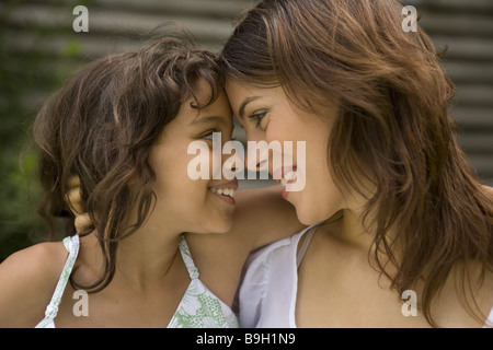 Mère fille embrasse amoureusement smiling portrait regarde à l'extérieur de 10 à 12 ans 11 ans 20-30 ans 30-40 ans abordé Banque D'Images