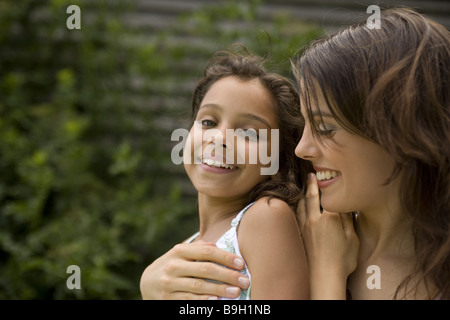 Mère fille embrasse smiling portrait avec amour à l'extérieur de 10 à 12 ans 11 ans 20-30 ans 30-40 ans à l'extérieur marron extérieur Banque D'Images