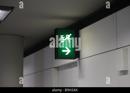 Sortie de secours signe dans un aéroport pour échapper à la sécurité en cas de danger de flèche étroite-Fire exit signe dans un aéroport pour secu Banque D'Images