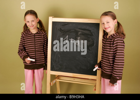 Les jumeaux fille tableau noir qu'ilne gaiement série détail personnes enfants 6-10 ans frères soeurs twin-soeurs lycéenne Banque D'Images