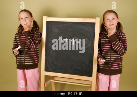 Les jumeaux fille tableau noir qu'ilne pensivement série détail personnes enfants 6-10 ans frères soeurs twin-soeurs lycéenne Banque D'Images