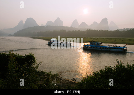 Chine, Province du Guangxi, Yangshuo, près de Guilin. Lever du soleil sur le paysage de montagne calcaire karstique sur la rivière Li Banque D'Images