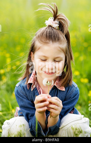 Little girl blowing the dandelion Banque D'Images