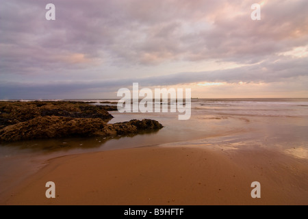 Lever du soleil à Seaham plage avec vue sur la mer du Nord avec bateau sur l'horizon Banque D'Images