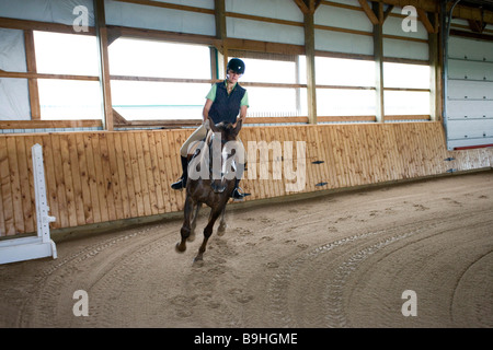 Amérique du Nord Canada Ontario teenage girl riding horse in arena Banque D'Images