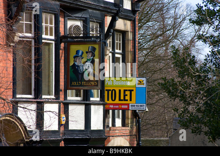 Vue sur la vieille enseigne de pub anglais avec un soit par le signe à côté de dépeindre la récession et l'effet sur le commerce pub Banque D'Images