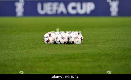 Ballons de football sur un terrain de football, en face de panneaux publicitaires avec le logo de l'UEFA-Cup Banque D'Images