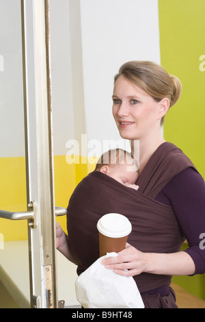 Mère en boutique avec bébé en porte-bébé Banque D'Images