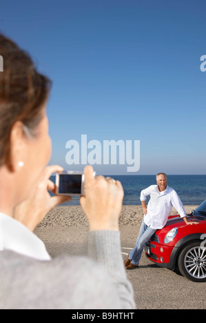 Woman taking photo de l'homme en voiture Banque D'Images