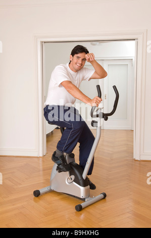 Sportsman sur un ergomètre dans le studio Banque D'Images