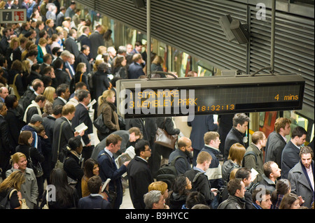 Les navetteurs sur plate-forme en attente de train bondé Canary Wharf Docklands Londres Royaume-Uni Banque D'Images