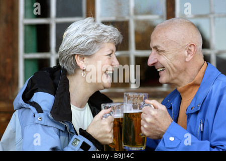 Vieux couple avec steins de bière Banque D'Images