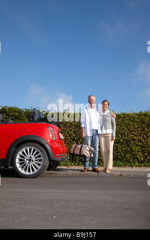 Mature couple standing next to car Banque D'Images