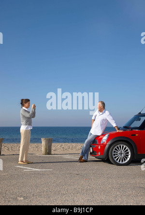 Woman taking photo de l'homme en voiture Banque D'Images