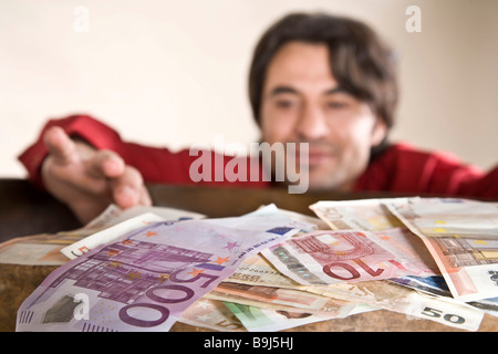 L'accaparement de l'homme à un tas d'argent Banque D'Images