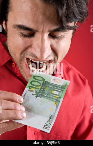 Homme mordre dans un projet de loi Euro 100 Banque D'Images