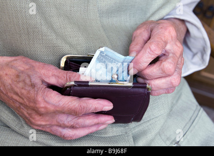 Une vieille dame en prenant un billet de son sac, détail Banque D'Images