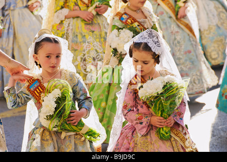 Les jeunes enfants Falleras marche vers la Place de la Vierge avec une fleur à l'épargne. Fallas Valencia Espagne Banque D'Images