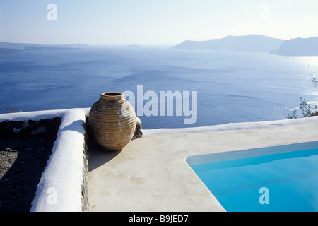 Piscine au bord d'un cratère d'un volcan dans la ville de Finikia, vue sur la caldeira, derrière l'île de Thirasia, Sant Banque D'Images