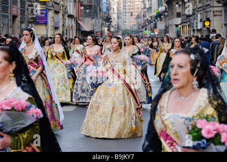 Falleras dans un défilé vers la Place de la Vierge avec des offrandes de fleurs . Fallas Valencia Espagne Banque D'Images