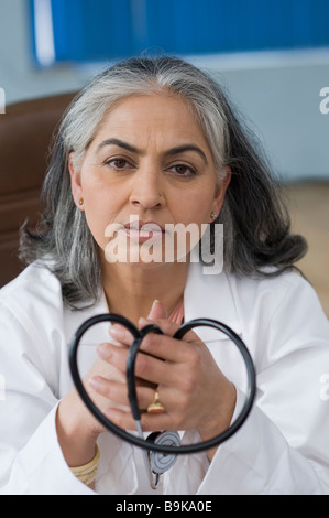 Femme médecin détenant un stéthoscope et images Banque D'Images