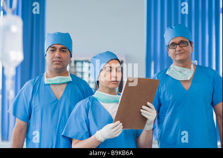 Doctor reading medical record à côté de ses collègues Banque D'Images