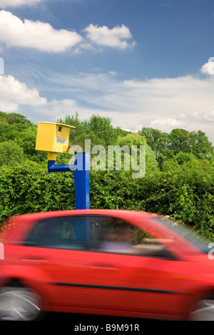 Voiture rouge en passant par un radar sur une route au Royaume-Uni Banque D'Images