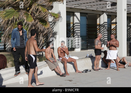 Les hommes à l'extérieur d'un bar sur la plage de St.Kilda, Australie Banque D'Images