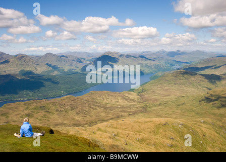 Femme mangeant son dîner tout en admirant la superbe vue depuis le haut de Ben Lomond, Stirlingshire, Scotland Banque D'Images